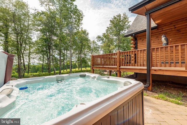 view of swimming pool with a wooden deck and a hot tub