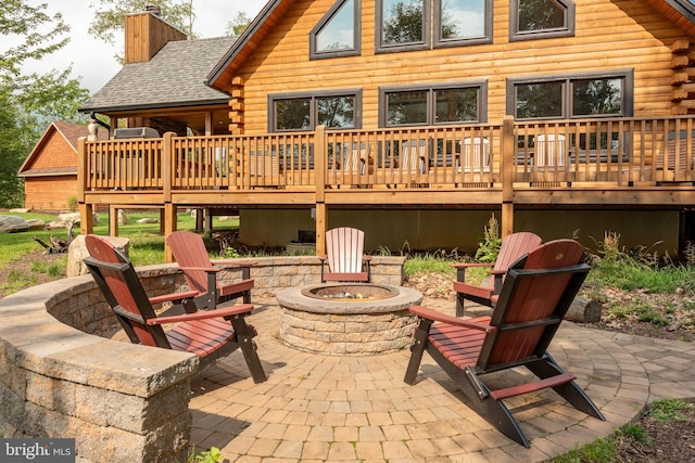 rear view of house with a patio area, a deck, and an outdoor fire pit