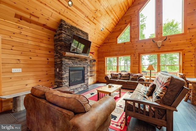 living room featuring high vaulted ceiling, wooden walls, a fireplace, wood ceiling, and hardwood / wood-style flooring