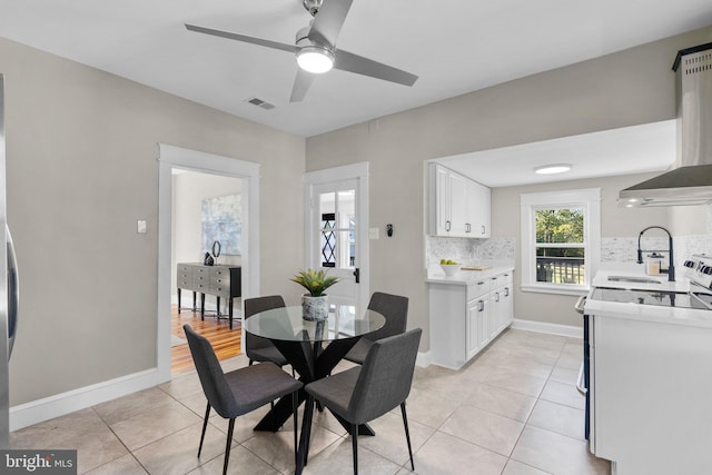 tiled dining area with sink and ceiling fan