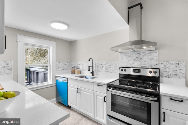 kitchen with wall chimney range hood, sink, stainless steel appliances, white cabinets, and decorative backsplash