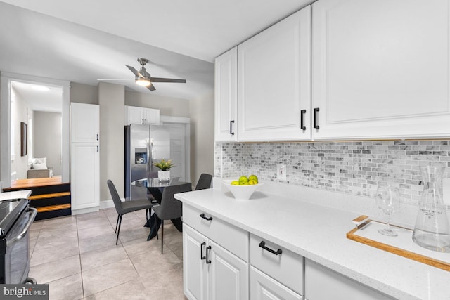 kitchen featuring light tile patterned floors, backsplash, white cabinetry, black electric range, and stainless steel refrigerator with ice dispenser