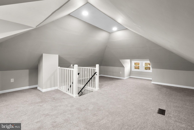 additional living space featuring vaulted ceiling and carpet flooring