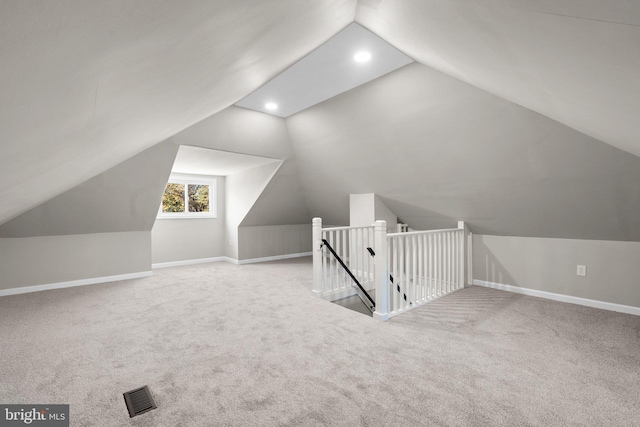 additional living space with light colored carpet and vaulted ceiling