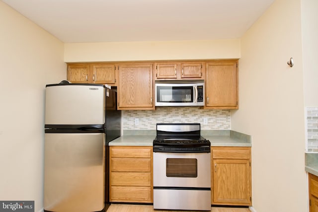 kitchen featuring stainless steel appliances and tasteful backsplash