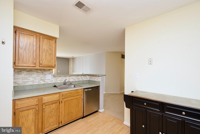 kitchen featuring sink, decorative backsplash, light hardwood / wood-style flooring, and stainless steel dishwasher