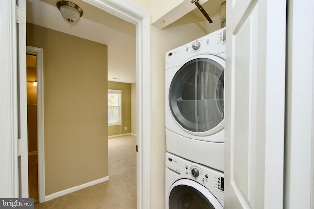 washroom featuring stacked washer / drying machine and light carpet