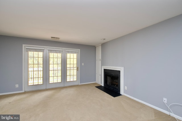 unfurnished living room featuring light carpet