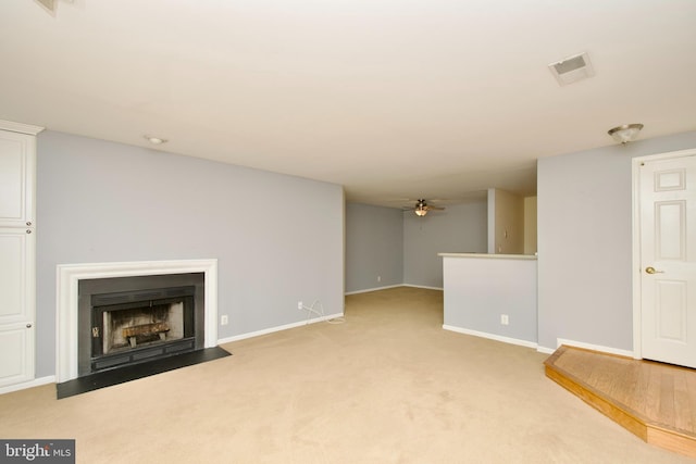 unfurnished living room with light carpet and ceiling fan