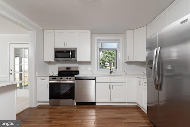 kitchen featuring white cabinetry, appliances with stainless steel finishes, dark hardwood / wood-style flooring, and sink