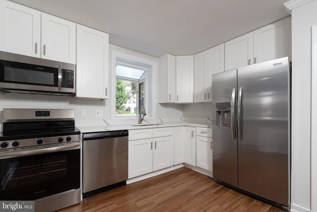 kitchen with white cabinetry, stainless steel appliances, sink, and dark hardwood / wood-style flooring