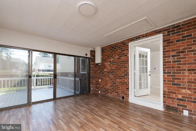 interior space with brick wall and wood-type flooring