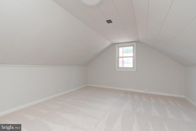 additional living space featuring lofted ceiling and light colored carpet