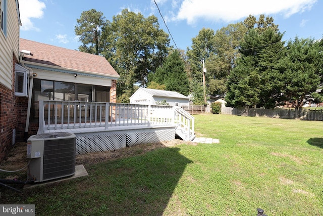 view of yard with central AC, a wooden deck, and a sunroom