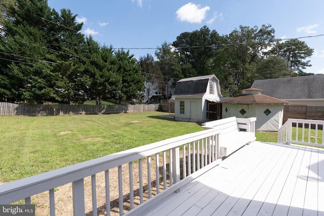 wooden deck with a storage shed and a lawn