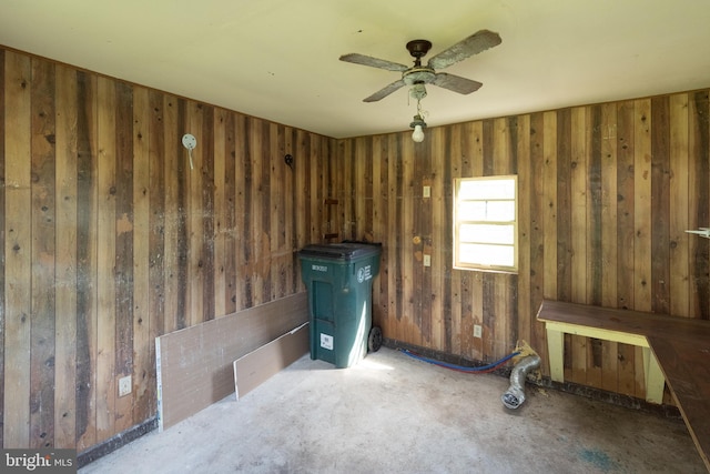 misc room featuring wood walls and ceiling fan