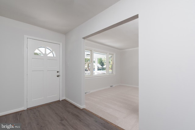 foyer entrance with crown molding, dark hardwood / wood-style floors, and a healthy amount of sunlight