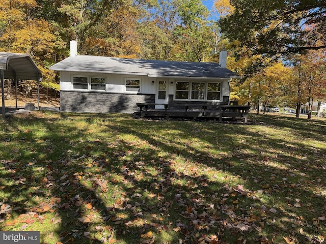 back of house with a yard, a deck, and a carport