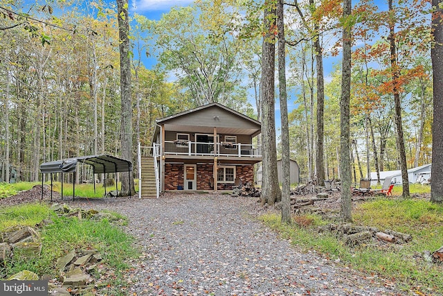 view of front of property with a wooden deck, a carport, and a balcony