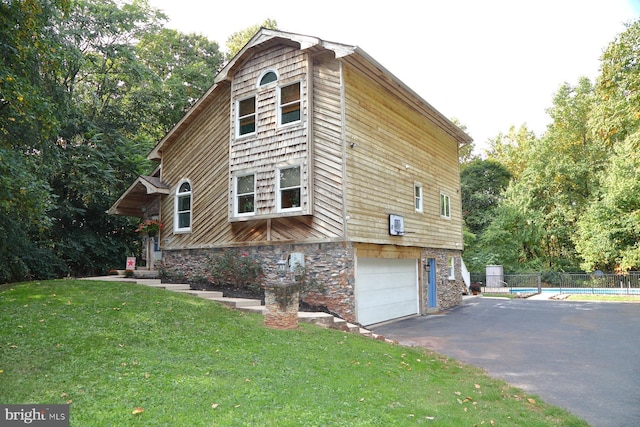 view of home's exterior featuring a garage, a yard, and a pool