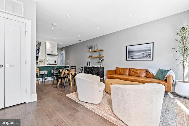 living room with hardwood / wood-style floors and sink