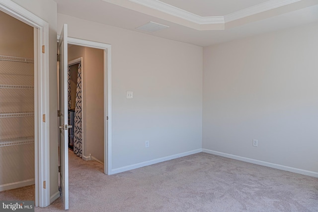 empty room featuring light colored carpet and crown molding