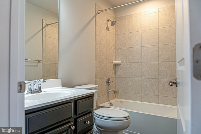 full bathroom with tiled shower / bath, vanity, and toilet