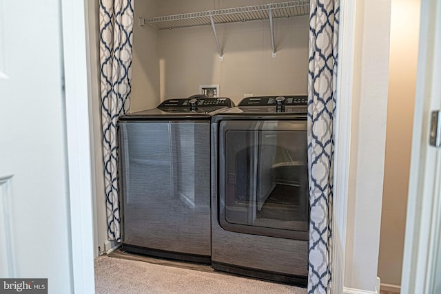 washroom with separate washer and dryer and light colored carpet