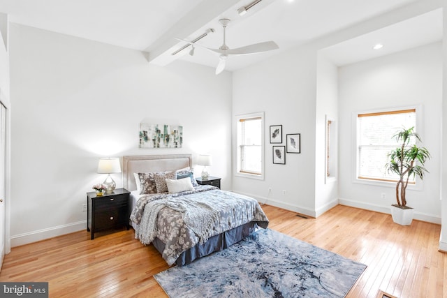 bedroom with beam ceiling, light hardwood / wood-style flooring, and ceiling fan