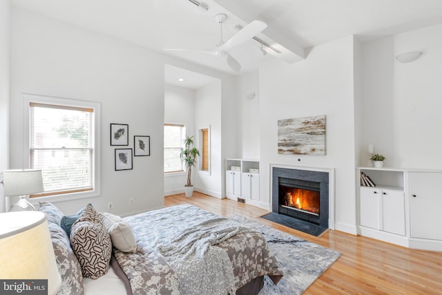 bedroom featuring ceiling fan, multiple windows, and hardwood / wood-style floors