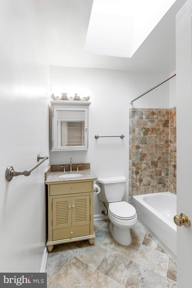 full bathroom featuring toilet, a skylight, vanity, and washtub / shower combination