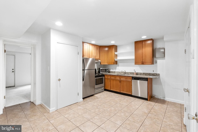 kitchen featuring appliances with stainless steel finishes, sink, light stone counters, and light tile patterned floors