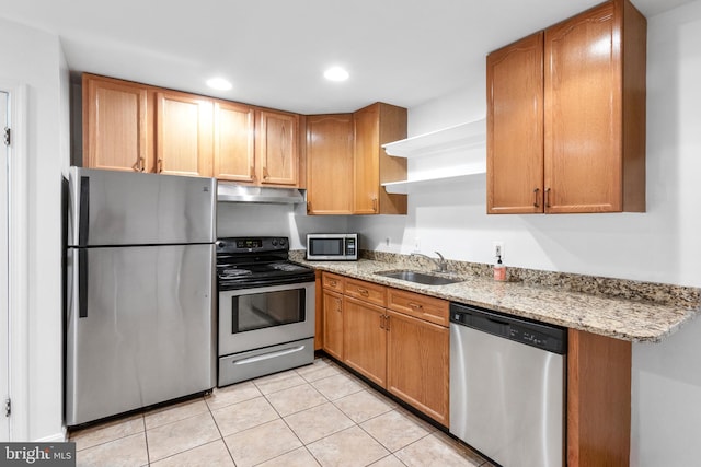 kitchen featuring sink, light stone countertops, stainless steel appliances, and light tile patterned floors