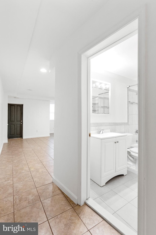 hallway with sink and light tile patterned floors