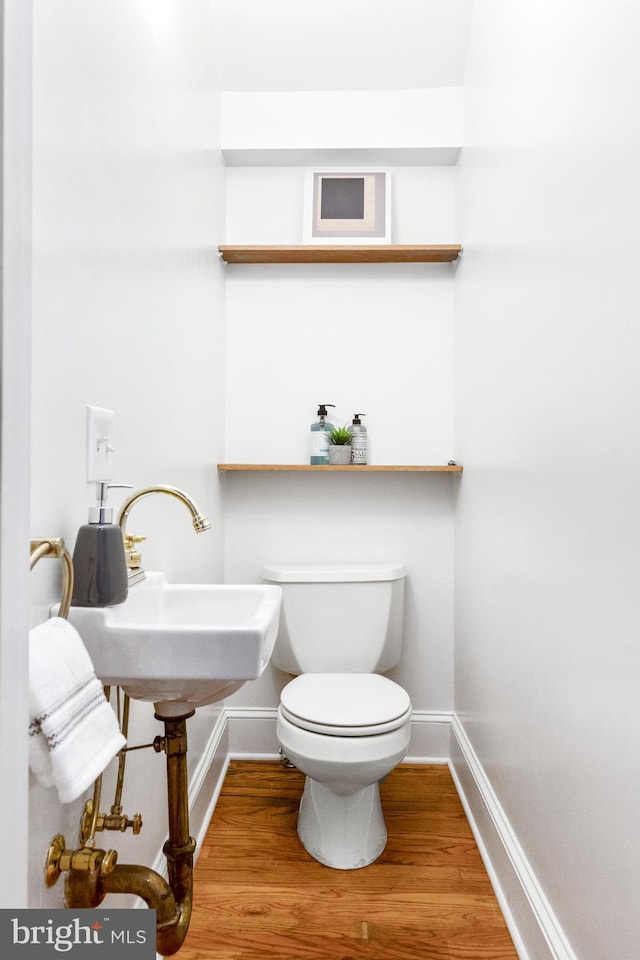 bathroom featuring toilet, hardwood / wood-style flooring, and sink