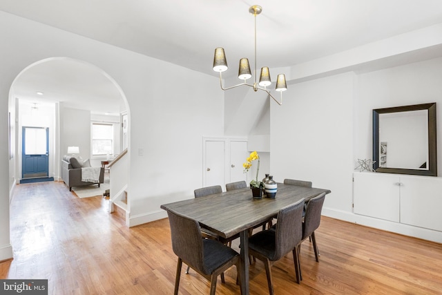 dining area with light hardwood / wood-style floors and an inviting chandelier