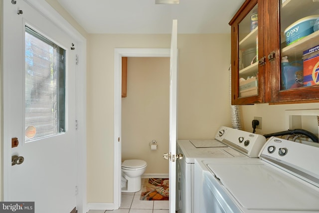 washroom with washer and dryer, cabinets, and light tile patterned floors