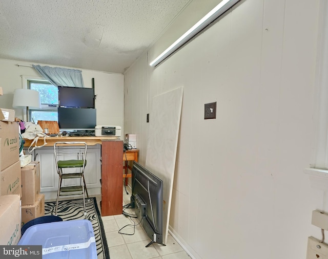 tiled home office with a textured ceiling