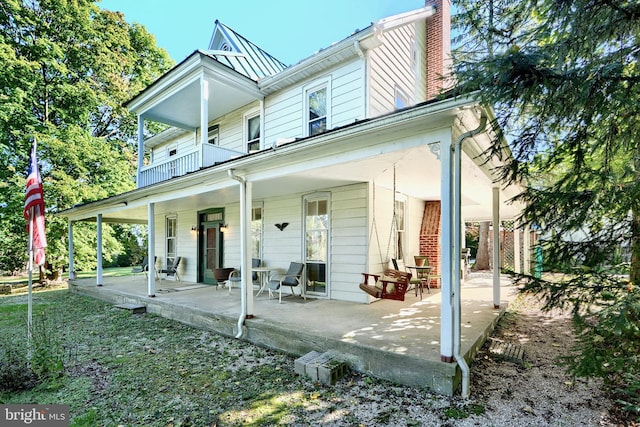 rear view of property with a patio and a balcony