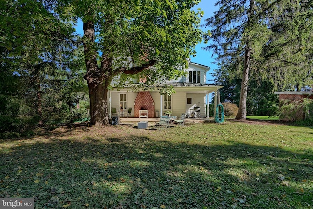 rear view of house with a porch and a lawn