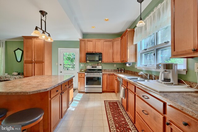 kitchen featuring stainless steel appliances, pendant lighting, sink, and light tile patterned floors