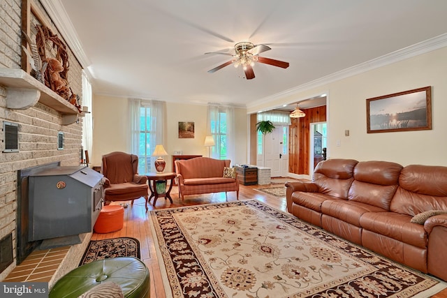 living room featuring a fireplace, ornamental molding, light hardwood / wood-style floors, and ceiling fan