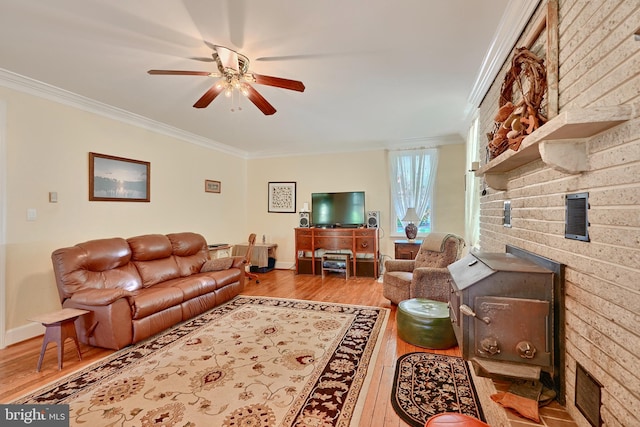 living room with a fireplace, ornamental molding, light hardwood / wood-style floors, and ceiling fan