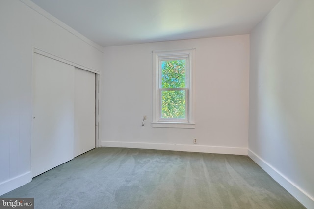 unfurnished bedroom with a closet and light colored carpet