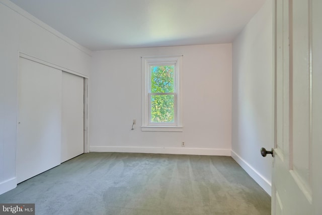 unfurnished bedroom featuring a closet and light colored carpet