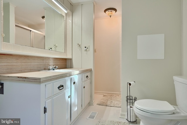 bathroom with vanity, tile patterned floors, an enclosed shower, toilet, and backsplash