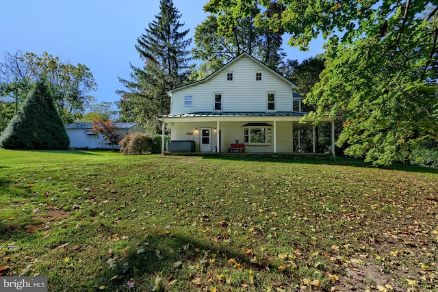 rear view of house with a lawn and covered porch