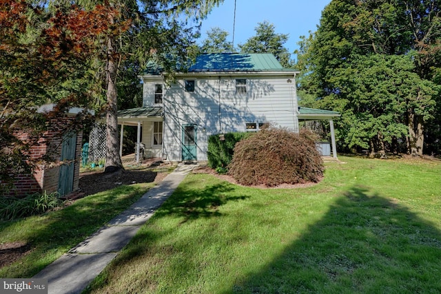 rear view of house featuring a yard