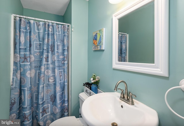 bathroom with sink, toilet, and curtained shower