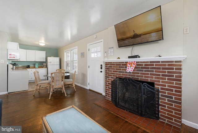 living room featuring a brick fireplace and dark hardwood / wood-style floors